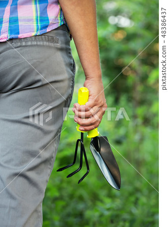 Woman's hand with garden tool 48386437