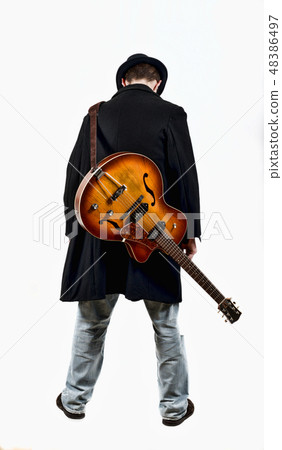 a guitarist with his guitar in the back a guitarist with his guitar in the back 48386497