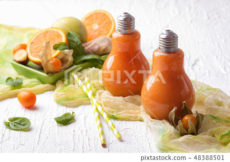 Two cups of orange and ginger smoothie with fruit 48388501