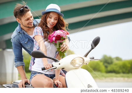 A man gives flowers beautiful woman. In the background the river 48389240