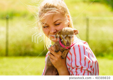 Woman playing with little dog outside 48389810