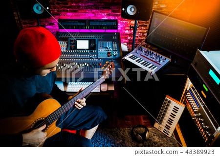 asian musician recording acoustic guitar in studio asian musician recording acoustic guitar in studio 48389923