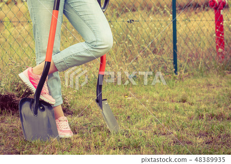Woman digging hole in garden 48389935