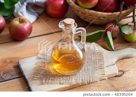 A bottle of apple cider vinegar with fresh apples A bottle of apple cider vinegar with fresh apples 48390204