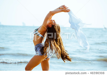 Young happy Caucasian woman on sea beach relaxing  48390308