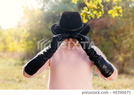 Woman holding hat Woman holding hat 48390875