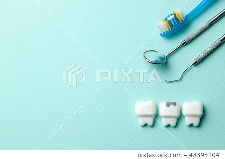 Healthy white teeth and tooth with caries on green mint background. Toothbrush and dentist tools Healthy white teeth and tooth with caries on green mint background. Toothbrush and dentist tools 48393104