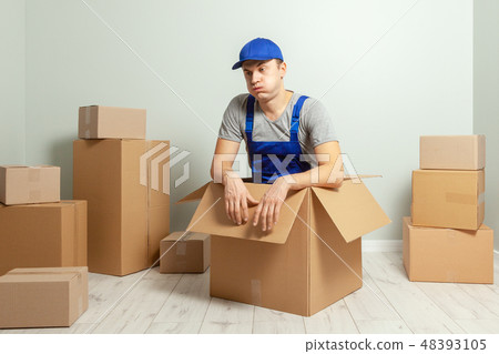 Day moving. Delivery of goods from shopping in the online store. Loader or courier tired against Day moving. Delivery of goods from shopping in the online store. Loader or courier tired against 48393105