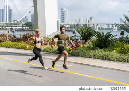 Young fitness couple running in urban area Young fitness couple running in urban area 48393865