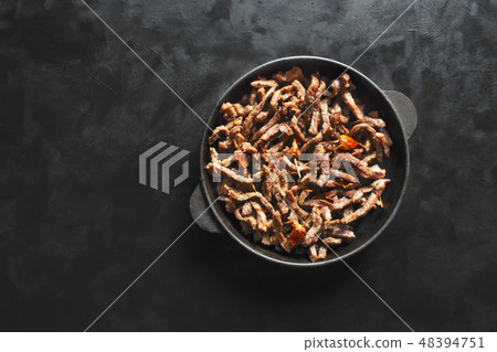 Fried beef stroganoff in a pan on black table. Fried beef stroganoff in a pan on black table. 48394751