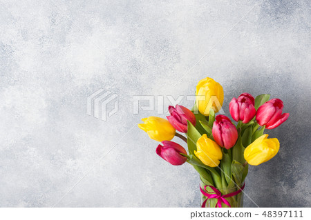 Bouquet of tulips yellow and pink on a gray Bouquet of tulips yellow and pink on a gray 48397111
