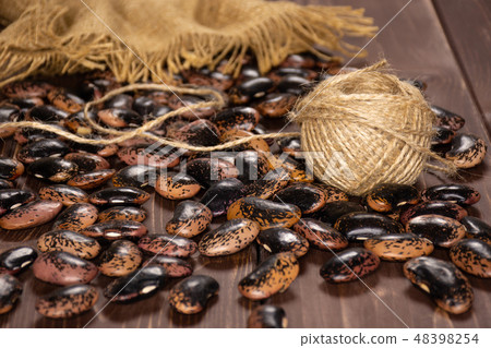 Speckled colored butter beans on brown wood 48398254