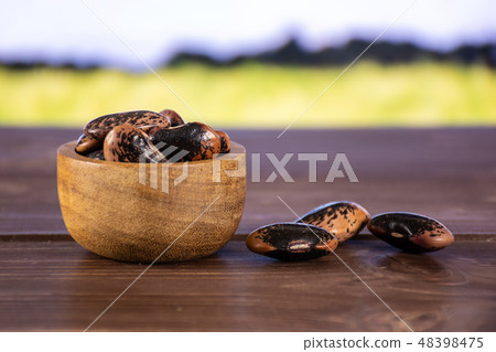 Speckled colored butter beans with field behind Speckled colored butter beans with field behind 48398475