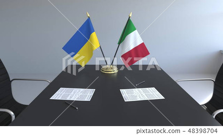 Flags of Ukraine and Italy and papers on the table. Negotiations and signing an international 48398704