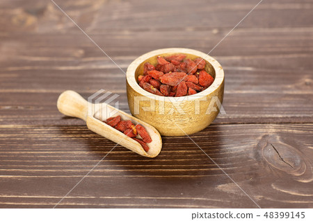 Dried red goji berries on brown wood Dried red goji berries on brown wood 48399145