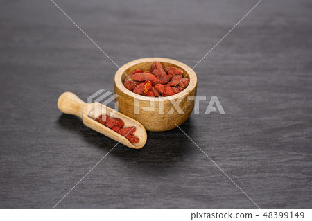 Dried red goji berries on grey stone Dried red goji berries on grey stone 48399149