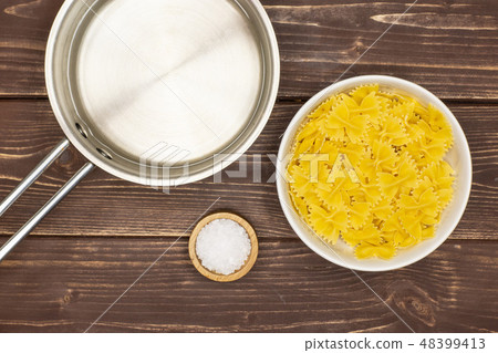 farfalle with arugula leaves on brown wood 48399413