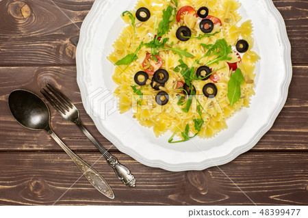 farfalle with arugula leaves on brown wood farfalle with arugula leaves on brown wood 48399477