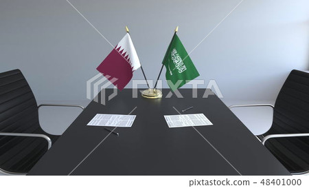 Flags of Qatar and Saudi Arabia and papers on the table. Negotiations and signing an international 48401000