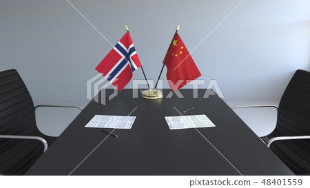 Flags of Norway and China and papers on the table. Negotiations and signing an international Flags of Norway and China and papers on the table. Negotiations and signing an international 48401559