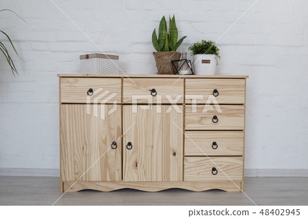 Interior living room with a wooden chest on a white brick wall Interior living room with a wooden chest on a white brick wall 48402945