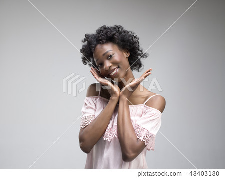 The happy african woman standing and smiling against gray background. The happy african woman standing and smiling against gray background. 48403180