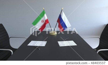 Flags of Iran and Russia and papers on the table. Negotiations and signing an international Flags of Iran and Russia and papers on the table. Negotiations and signing an international 48403537