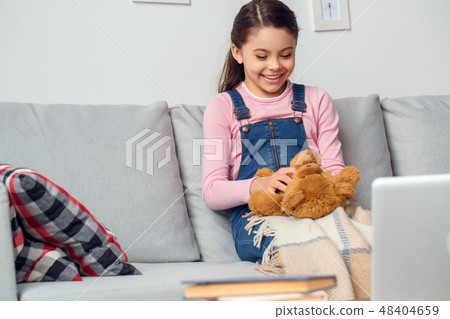Little girl at home sitting playing with teddy bear joyful Little girl at home sitting playing with teddy bear joyful 48404659