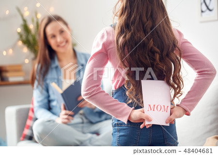 Mother and daughter at home mother's day daughter holding greeting card 48404681