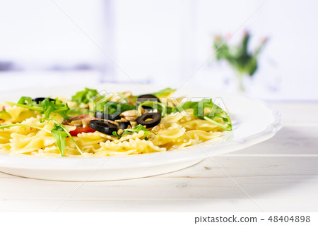 Recipe farfalle with arugula on white with flowers Recipe farfalle with arugula on white with flowers 48404898