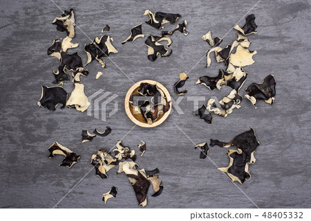 Dry black mushroom jew ear on grey stone Dry black mushroom jew ear on grey stone 48405332