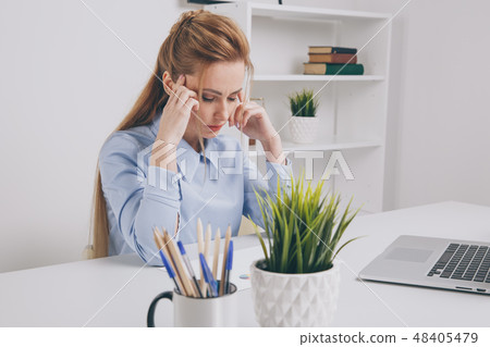 Young office girl sitting at her workplace feeling bad. Woman has a headache. Young office girl sitting at her workplace feeling bad. Woman has a headache. 48405479