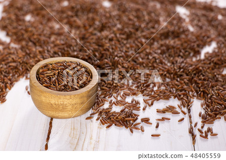 Raw red rice on grey wood 48405559