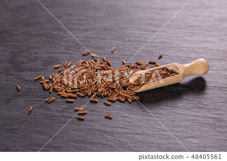 Raw red rice on grey stone Raw red rice on grey stone 48405561