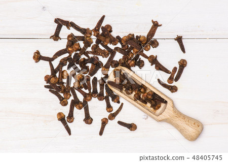 Small dried cloves spice on grey wood Small dried cloves spice on grey wood 48405745