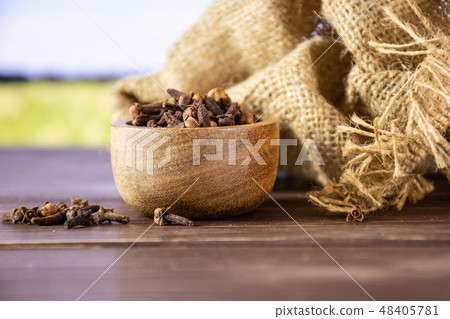 Small dried cloves spice with field behind Small dried cloves spice with field behind 48405781