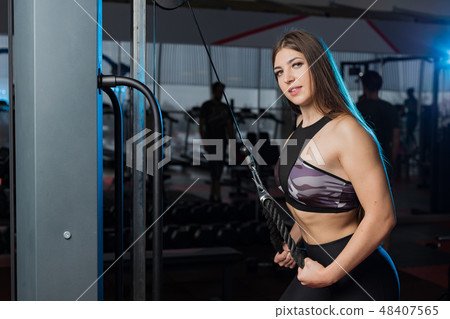 girl in a gym doing triceps exercises on block 48407565