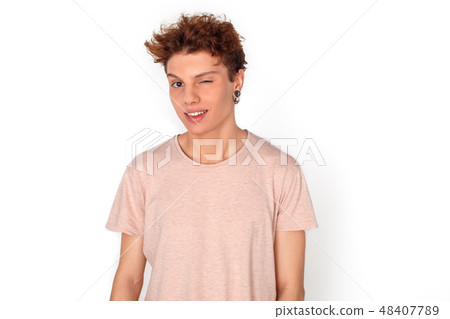 Teenager with earrings studio standing isolated on white winking camera playful 48407789