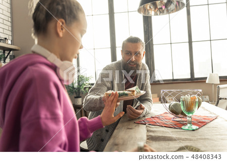 Caring father giving plate with sandwich to his daughter Caring father giving plate with sandwich to his daughter 48408343