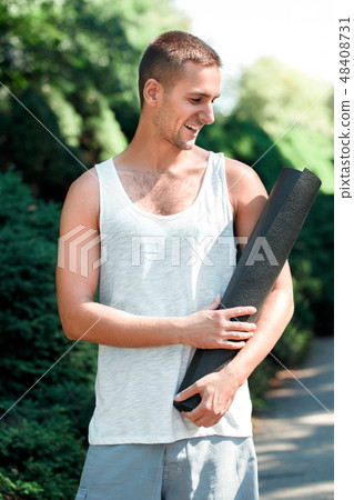 Healthy Lifestyle. Man practicing yoga outdoors standing looking at mat cheerful 48408731