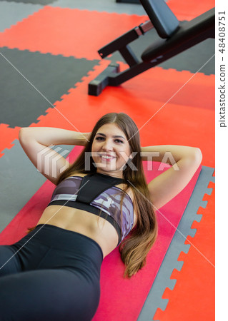 Beautiful girl trains press on the floor in the 48408751