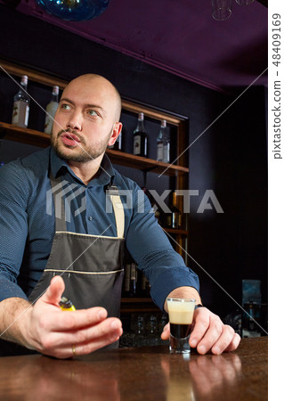 The bartender prepares a B-52 cocktail at the bar The bartender prepares a B-52 cocktail at the bar 48409169
