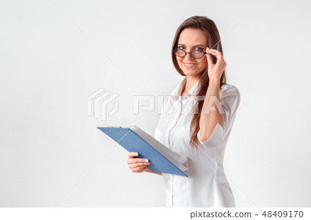 Business meeting. Woman in eyeglasses standing isolated on white with clipboard and pen preparing Business meeting. Woman in eyeglasses standing isolated on white with clipboard and pen preparing 48409170