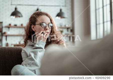 Girl wearing glasses feeling thoughtful talking to therapist Girl wearing glasses feeling thoughtful talking to therapist 48409290