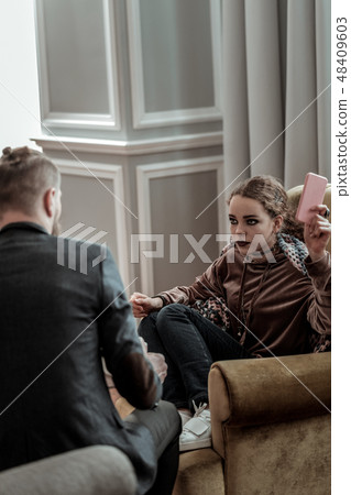 Counselor wearing dark jacket listening to depressed teenager 48409603