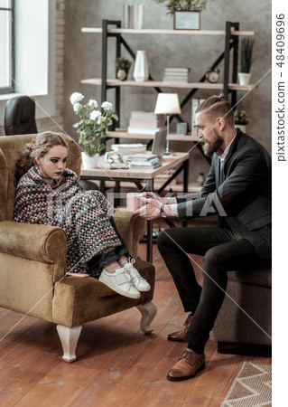 Stressed teenage girl wearing white sneakers visiting counselor 48409696