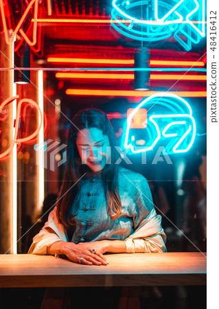 Beautiful girl in a window cafe and looks at the camera Beautiful girl in a window cafe and looks at the camera 48416412