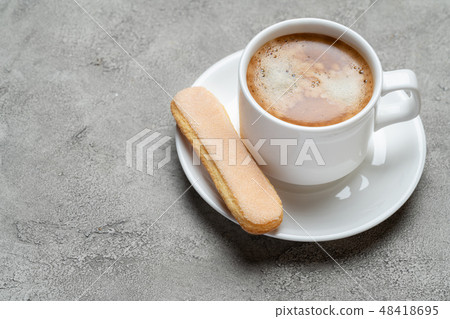 Italian Savoiardi ladyfingers Biscuits and cup of coffee on concrete backgound Italian Savoiardi ladyfingers Biscuits and cup of coffee on concrete backgound 48418695