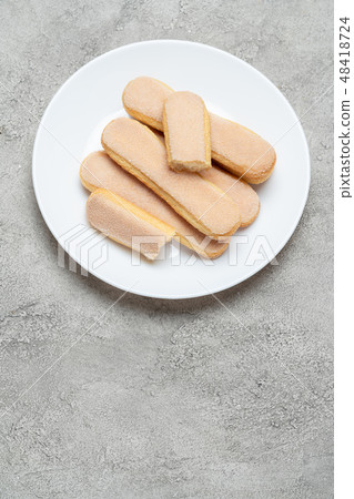 Italian Savoiardi ladyfingers Biscuits in plate on concrete backgound Italian Savoiardi ladyfingers Biscuits in plate on concrete backgound 48418724