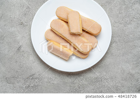 Italian Savoiardi ladyfingers Biscuits in plate on concrete backgound Italian Savoiardi ladyfingers Biscuits in plate on concrete backgound 48418726